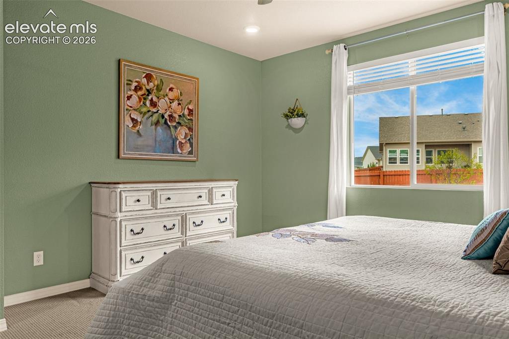 Image 16 of 40: Recessed lighting, large window with blinds, light green walls, and carpete