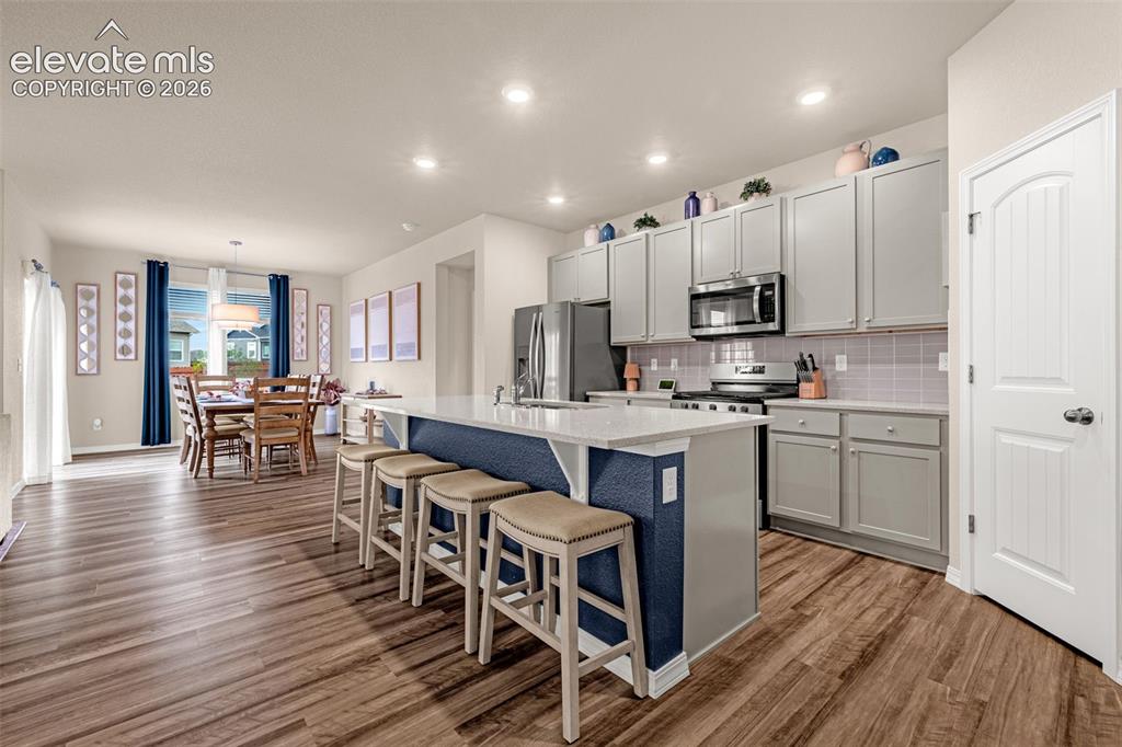 Image 2 of 40: Spacious kitchen featuring an island with counter seating, stainless steel 