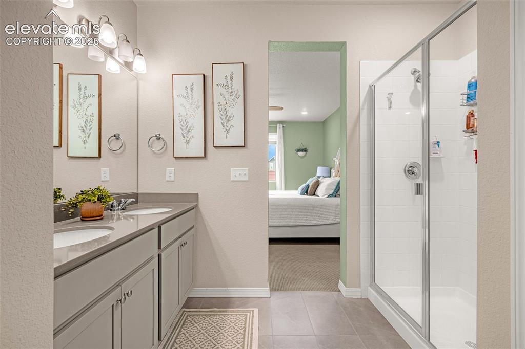 Image 22 of 40: Dual sink vanity with stone-finish countertop, separate glass-enclosed show