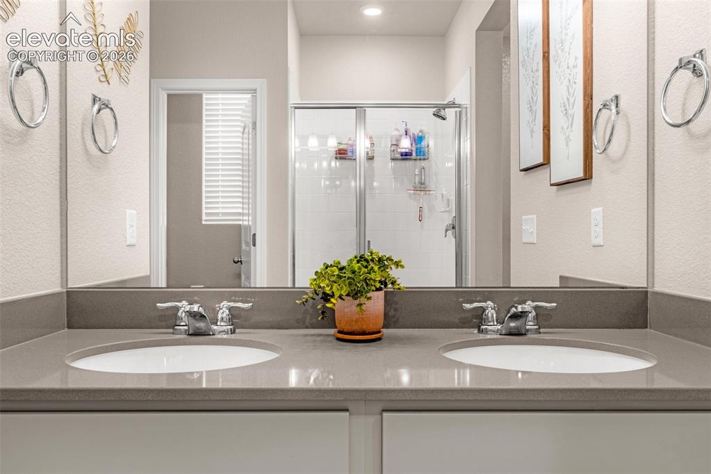 Image 23 of 40: Dual undermount sinks, chrome faucets, and a solid surface countertop