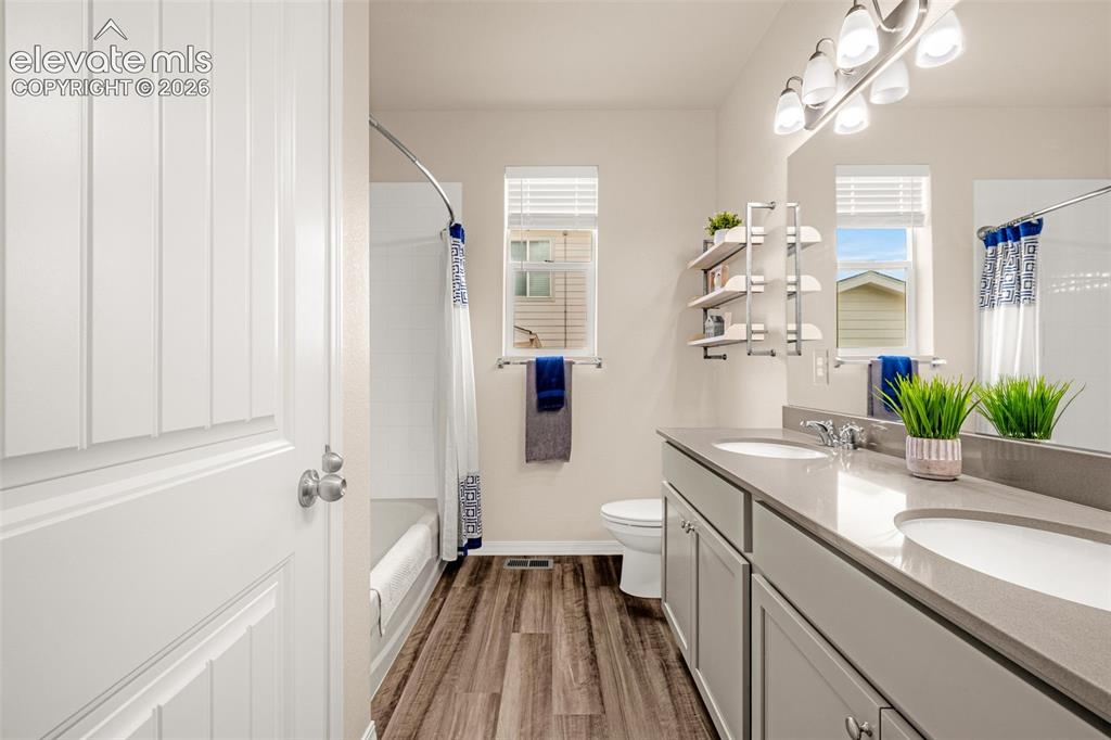 Image 26 of 40: Dual vanity with undermount sinks, gray cabinetry, and light-toned countert