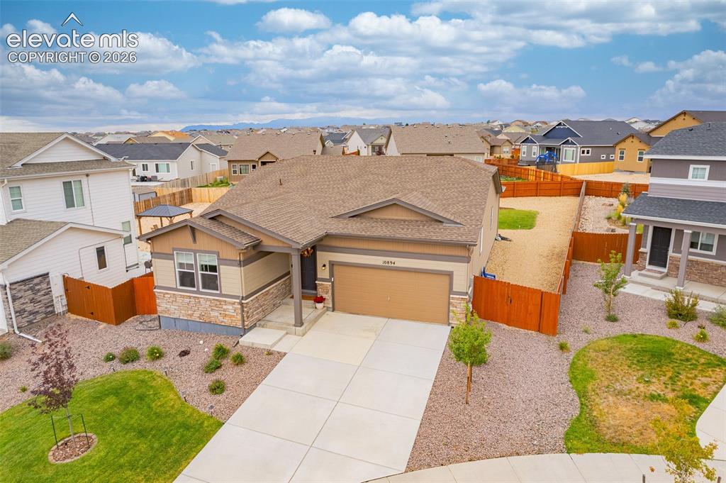 Image 34 of 40: Multi-tone exterior with stone accents, attached two-car garage, concrete d