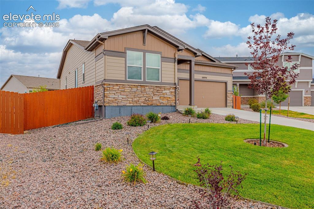 Image 37 of 40: Traditional-style exterior with stone veneer accents, an attached garage, a