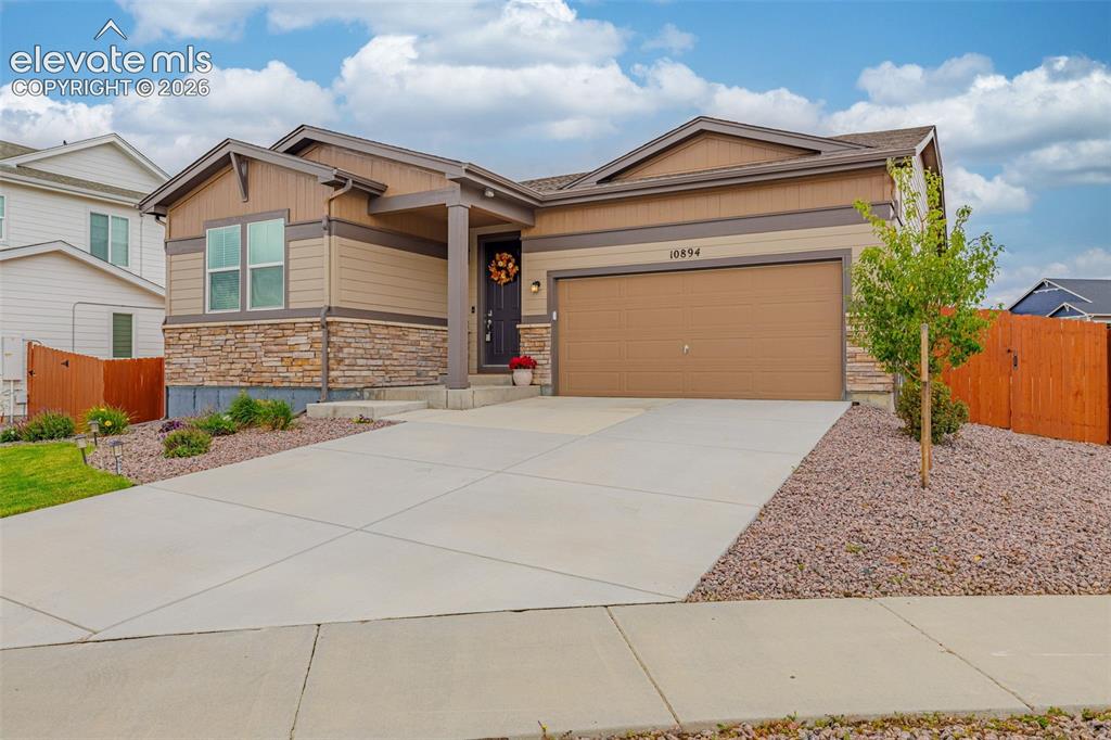 Image 39 of 40: Modern exterior featuring stone veneer accents, an attached garage, a cover