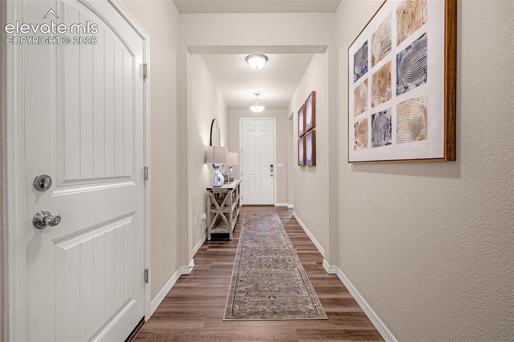 Image 40 of 40: Wood-finish flooring throughout, framed entryway, and ceiling-mounted light