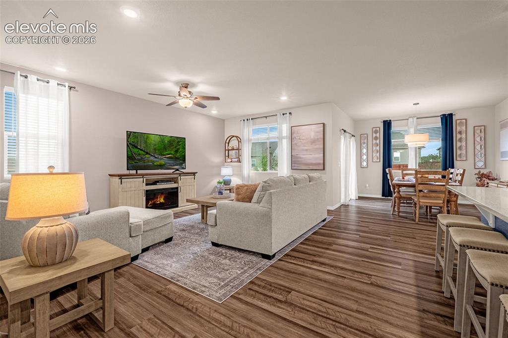 Image 6 of 40: Open-concept living space featuring wood-finish flooring, recessed lighting