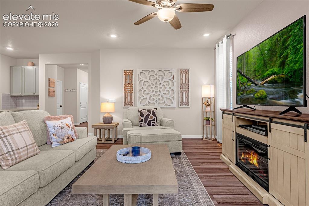 Image 8 of 40: Recessed lighting, wood-finish flooring, ceiling fan, and light-toned walls