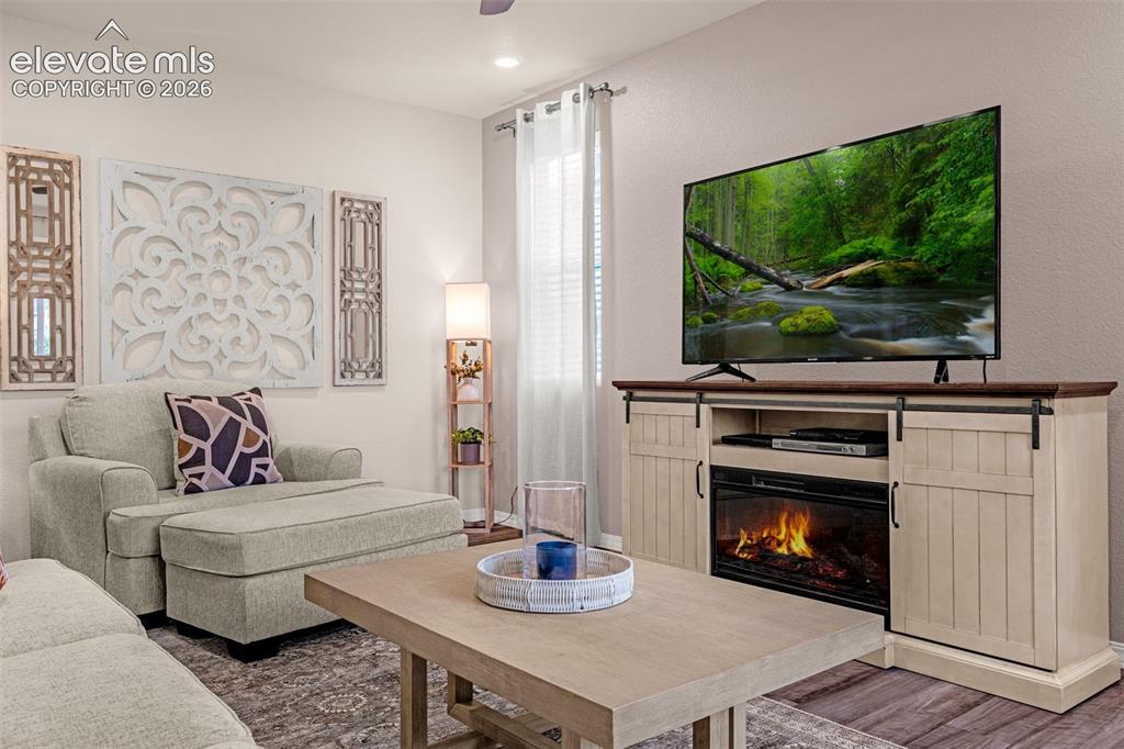 Image 9 of 40: Built-in console with a faux fireplace and barn door accents, recessed ligh