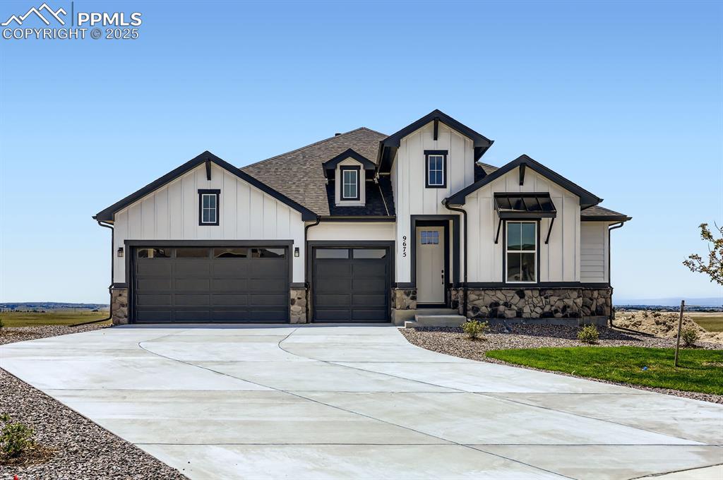 Caption: Modern farmhouse featuring board and batten siding, a shingled roof, driveway, stone siding, and an 