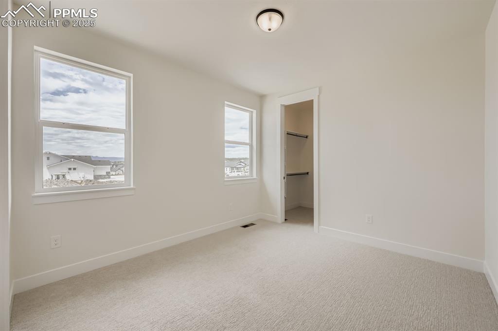 Image 18 of 29: Unfurnished bedroom featuring light carpet and a spacious closet
