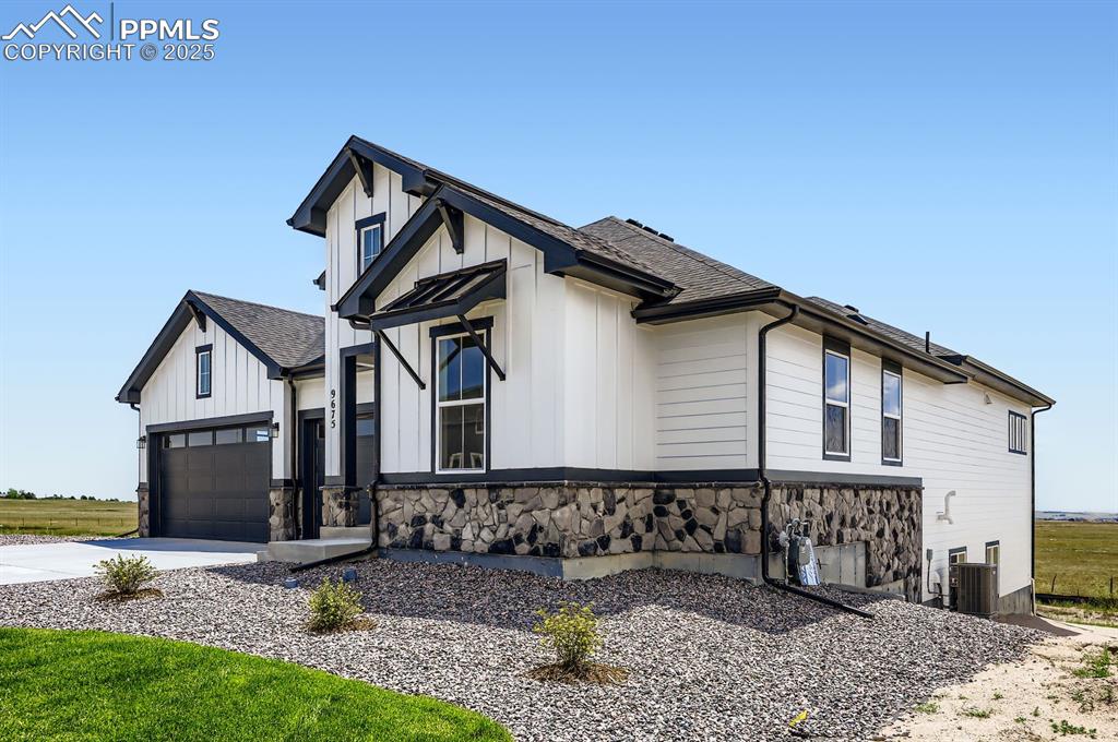 Image 3 of 29: View of side of home with board and batten siding, driveway, roof with shin