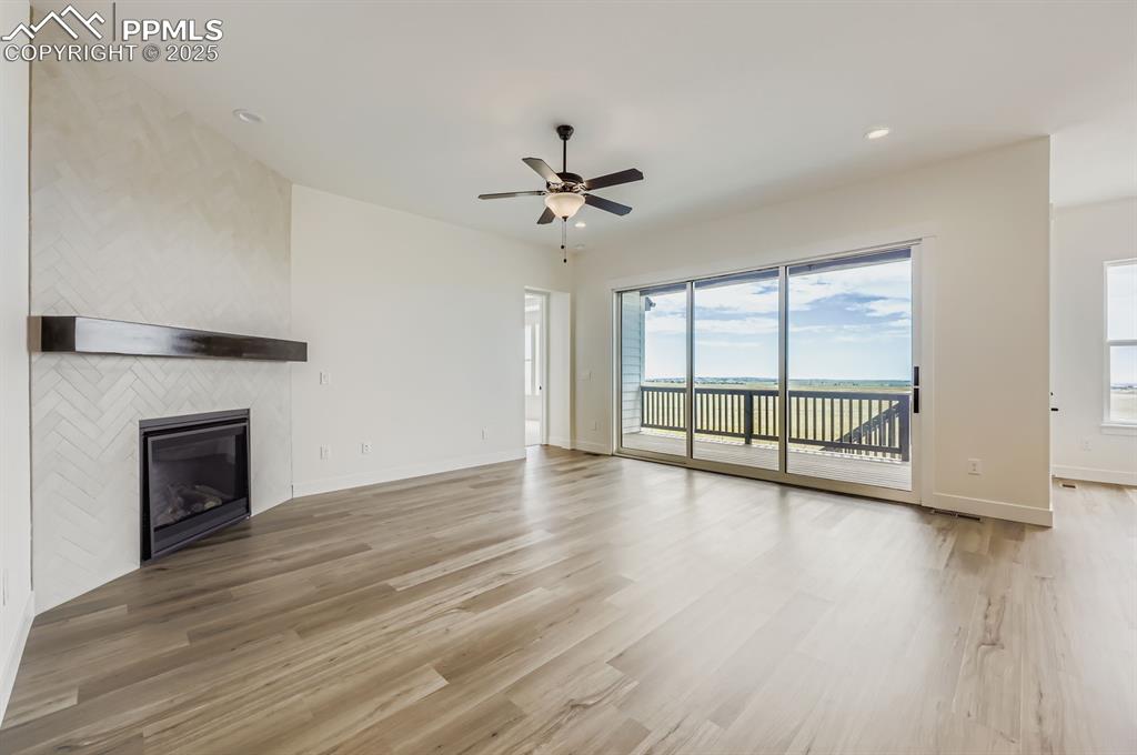 Image 5 of 29: Unfurnished living room featuring ceiling fan, light wood-style flooring, r