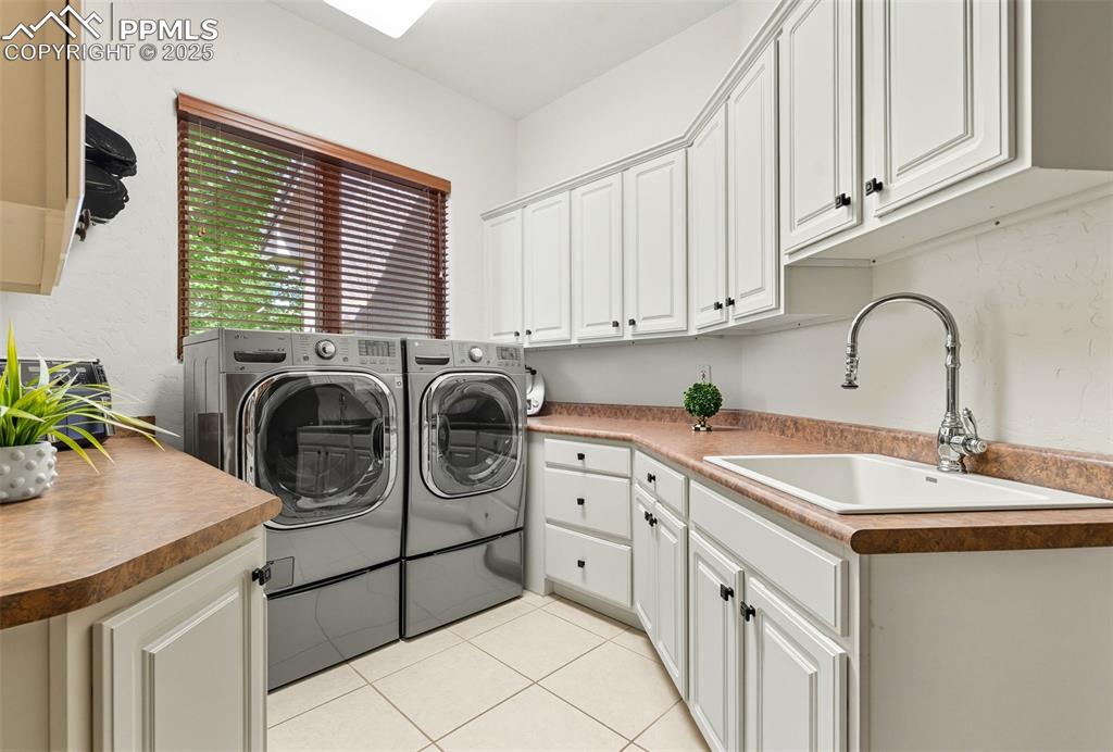 Image 26 of 50: A great laundry room with loads of storage and the washer and dryer will re