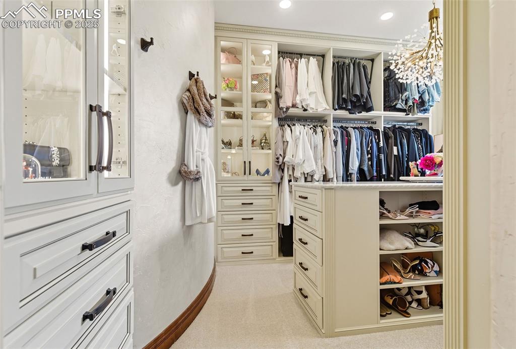 Image 33 of 50: exquisite primary closet by the Closet Factory. Pull down rods from the upp