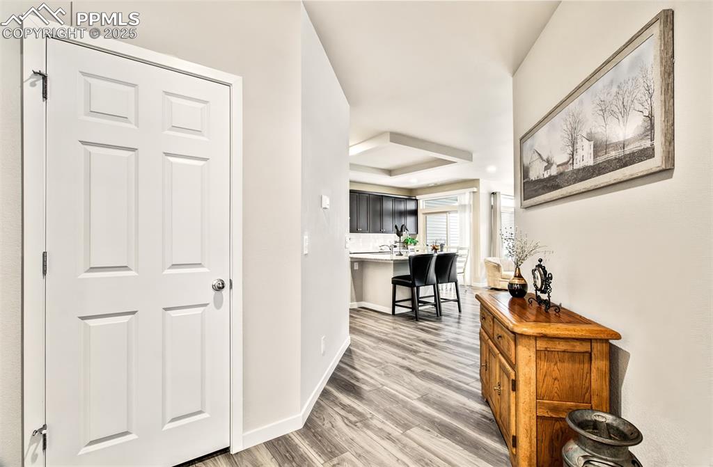 Image 10 of 39: Corridor featuring a raised ceiling, light wood-type flooring, and baseboar
