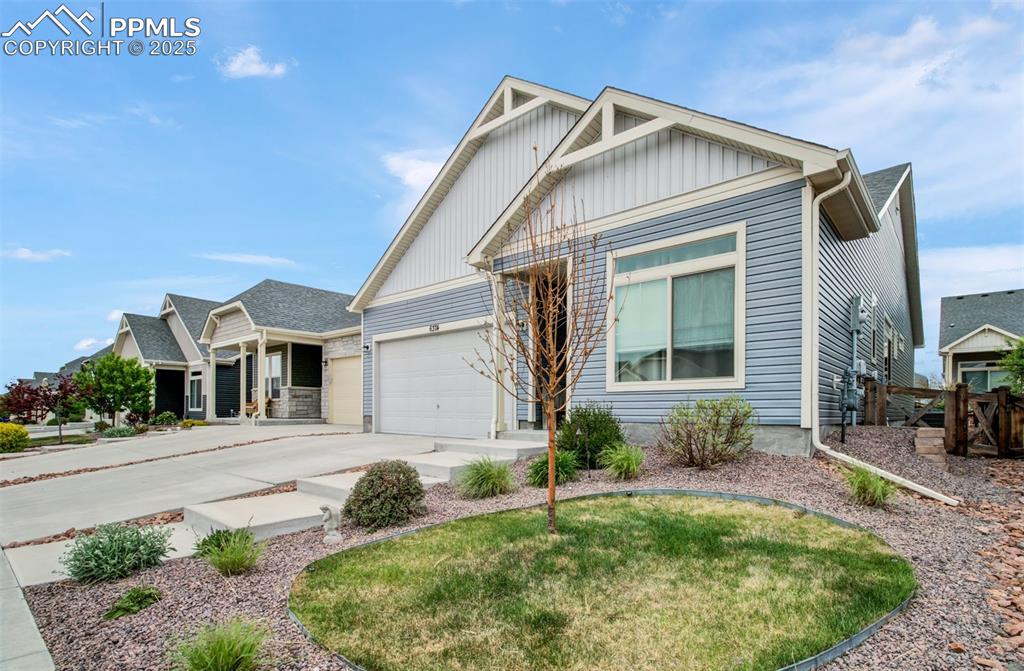 Image 2 of 39: Ranch-style house with concrete driveway.