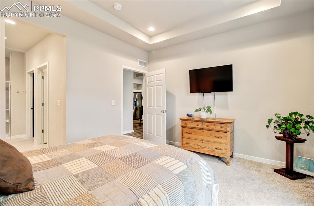 Image 21 of 39: Bedroom featuring baseboards, recessed lighting, light carpet, stainless st