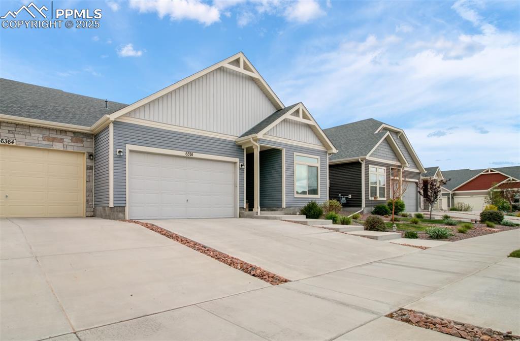 Image 3 of 39: View of front facade featuring board and batten siding, driveway, an attach