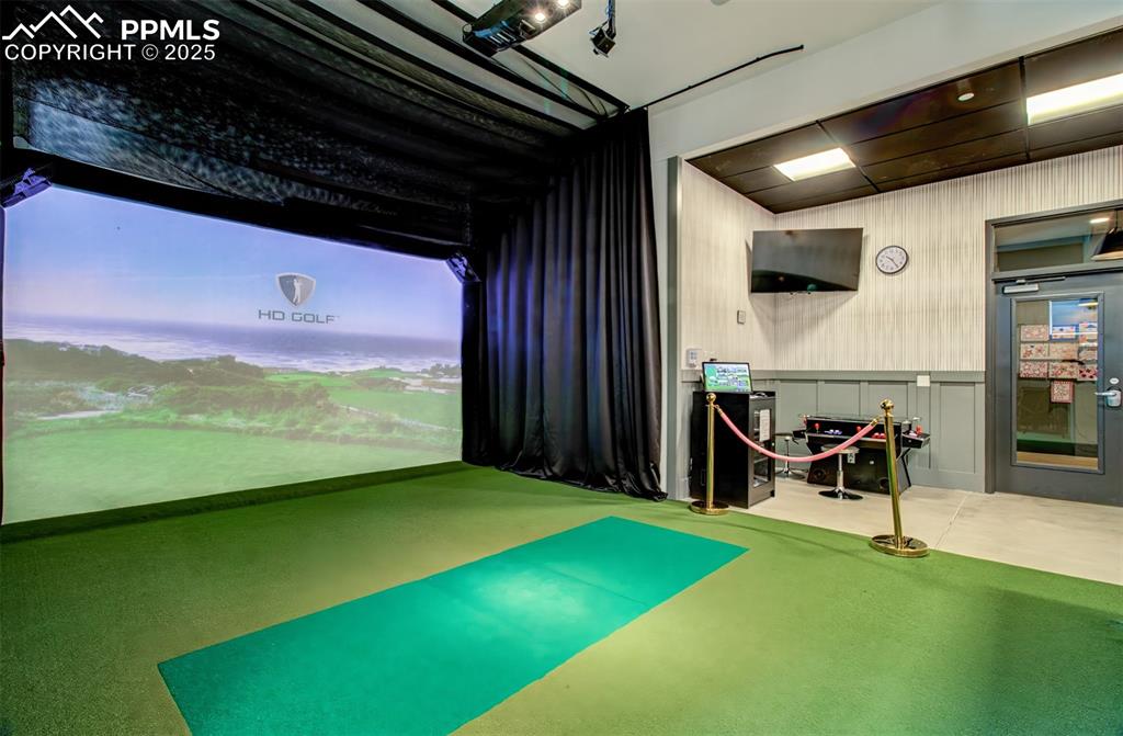 Image 36 of 39: Playroom with golf simulator and carpet flooring