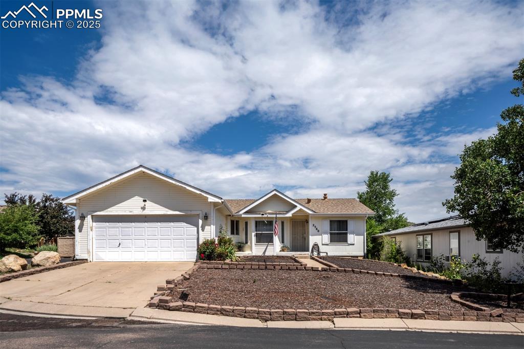 Caption: Ranch-style home with a garage, driveway, and covered porch