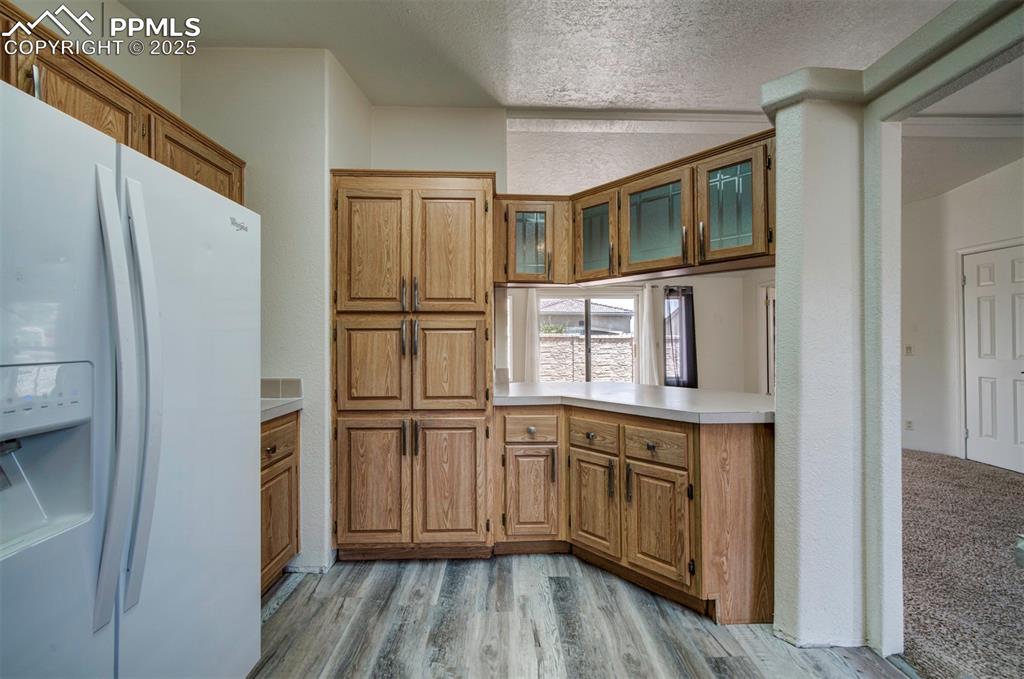 Image 11 of 31: Kitchen featuring white refrigerator with ice dispenser, a textured ceiling