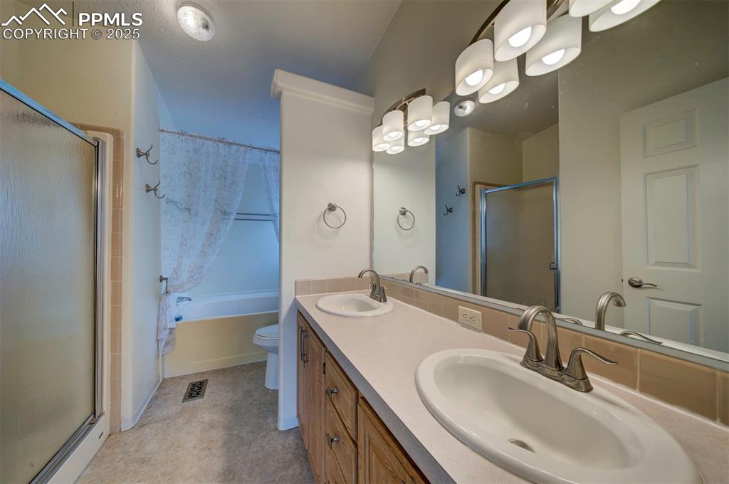 Image 18 of 31: Bathroom with a shower with shower door, double vanity, and a tub