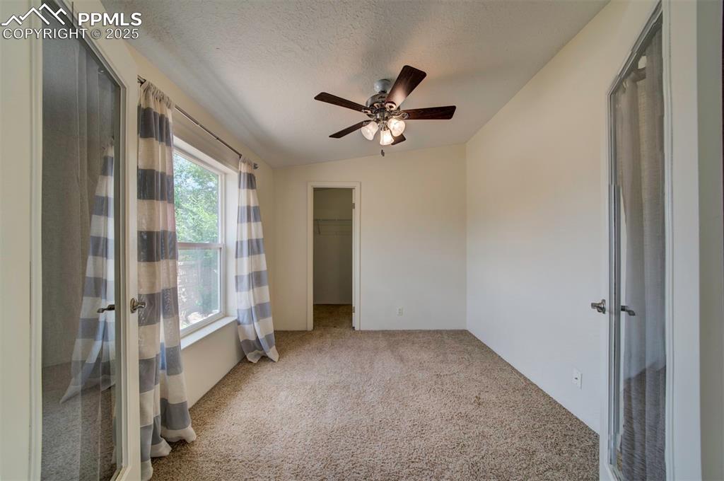 Image 19 of 31: Empty room featuring carpet, ceiling fan, a textured ceiling, and vaulted c