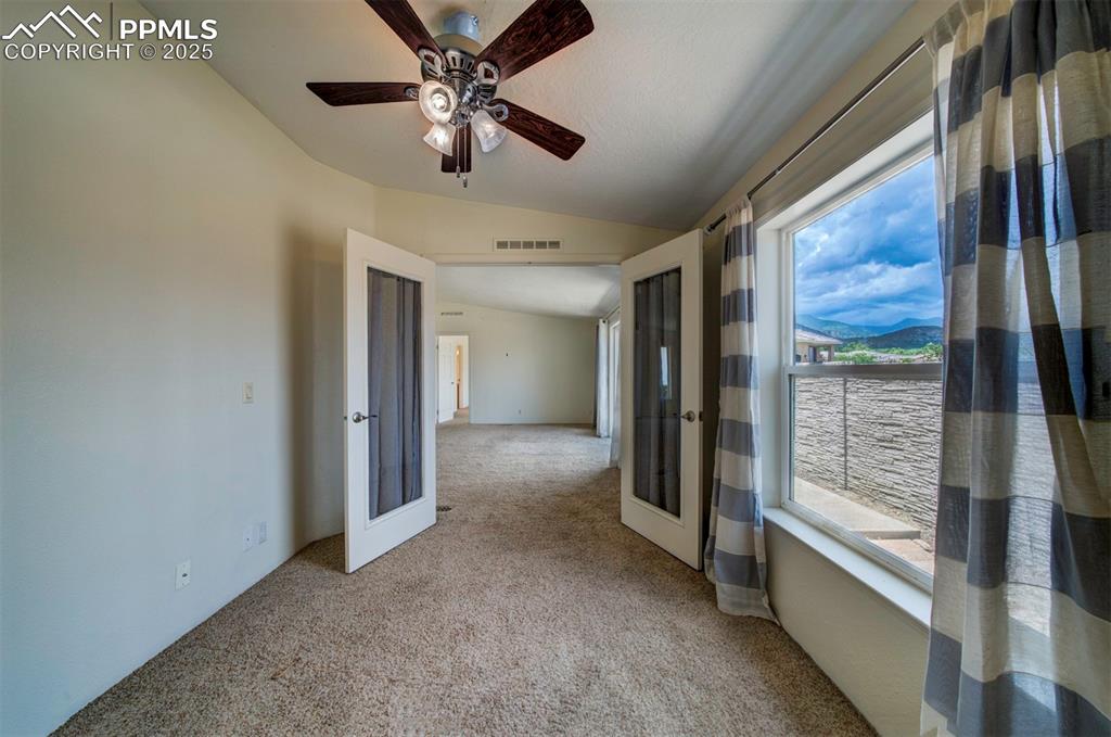 Image 23 of 31: Spare room with light carpet, french doors, vaulted ceiling, and a ceiling