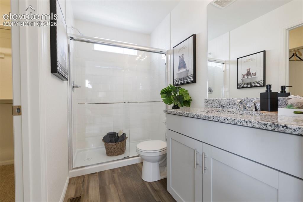 Image 11 of 20: Bathroom featuring a white vanity with granite-style countertop, a chrome f