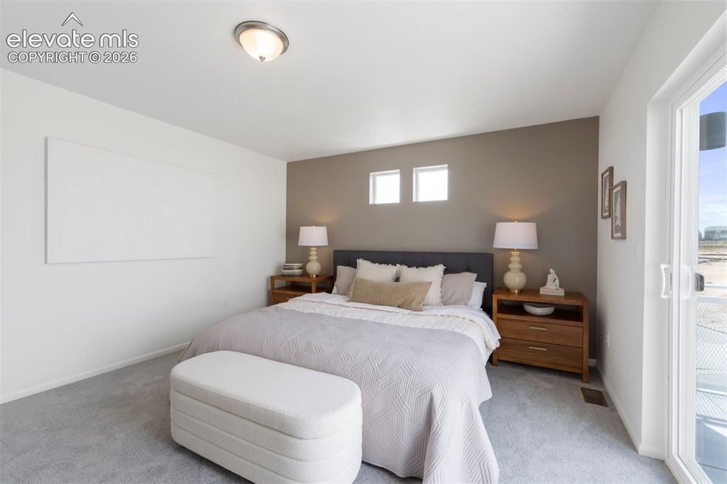 Image 13 of 20: Bedroom featuring light gray carpeting, a two-tone wall treatment, and a sa