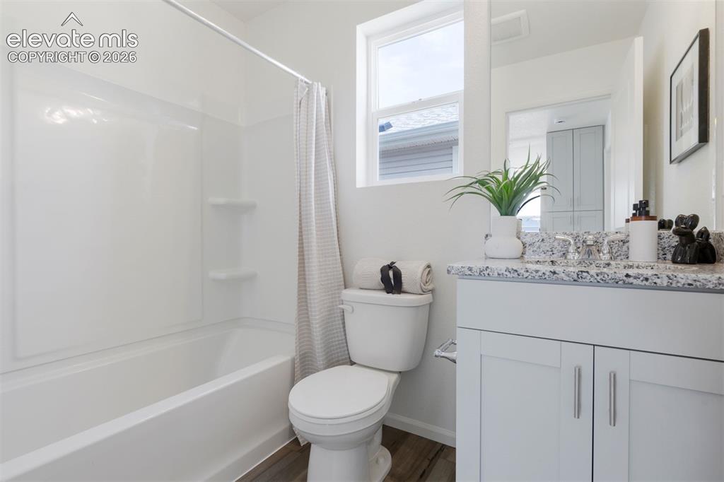 Image 15 of 20: Bathroom featuring a white bathtub/shower combination, a toilet, and a vani