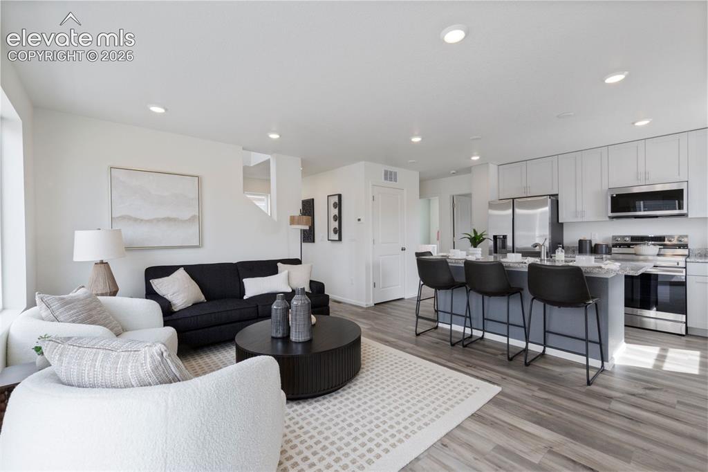 Image 4 of 20: Open concept living space featuring wood-finish flooring, recessed lighting
