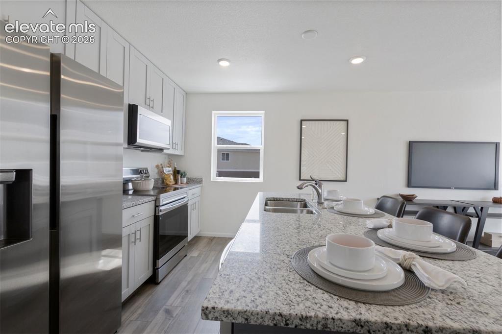 Image 7 of 20: Kitchen featuring an island with a double basin sink and a stainless steel 