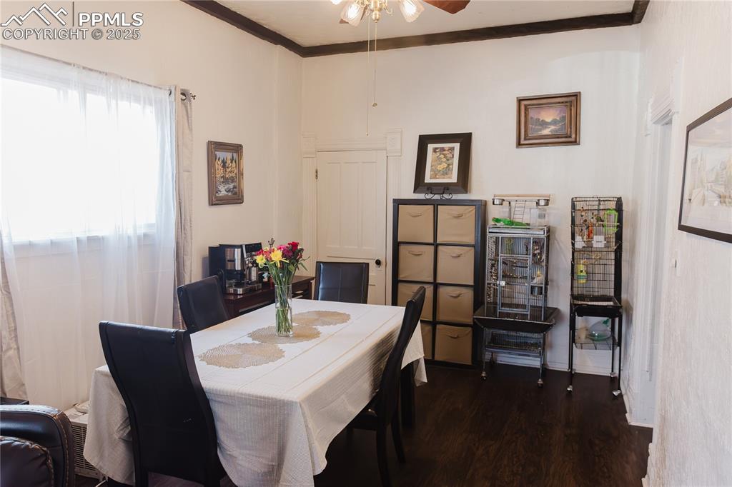 Image 8 of 28: Dining area with ornamental molding, ceiling fan, and wood finished floors
