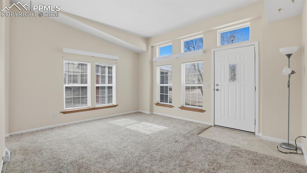 Image 3 of 37: Front Entry into the Formal Living Room with neutral carpet and lots of win