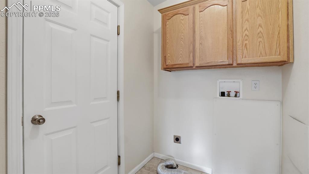 Image 5 of 37: The Laundry Room has upper cabinets and garage access.