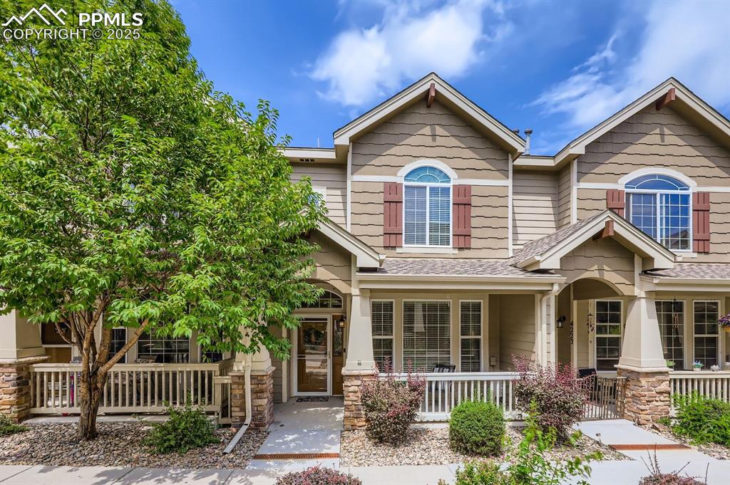 Caption: Craftsman house with a porch, stone siding, and a shingled roof