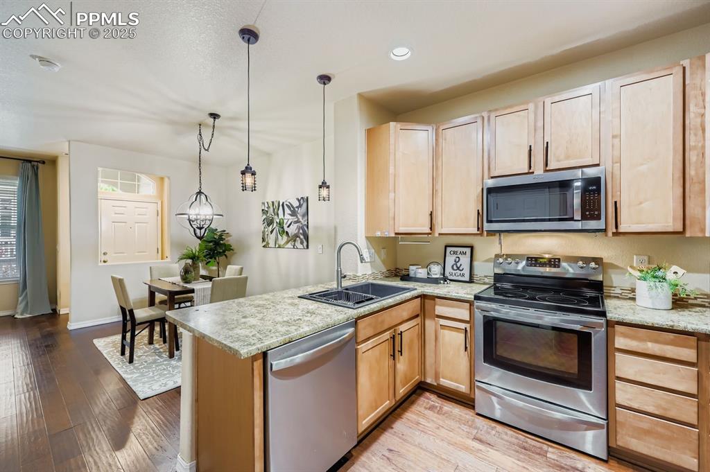 Image 5 of 10: Kitchen featuring appliances with stainless steel finishes, light counterto
