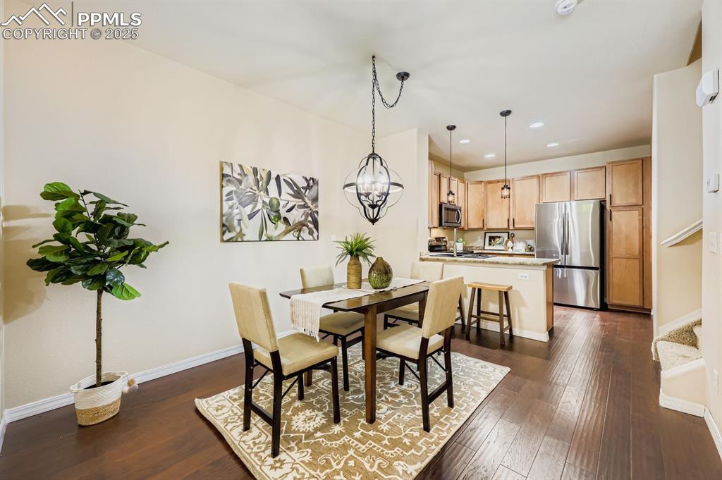 Image 6 of 10: Dining area featuring dark wood finished floors, recessed lighting, a chand