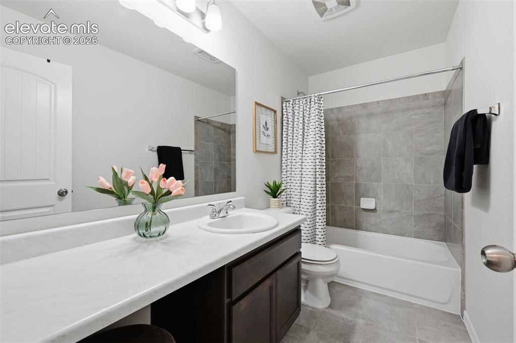 Image 29 of 42: Upstairs full bath with quartz countertops and vanity space