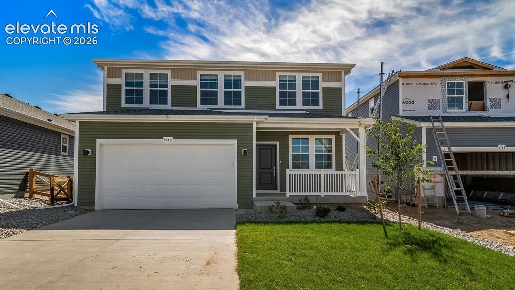 Image 1 of 39: Two-story residence featuring a two-car garage, front porch with white rail