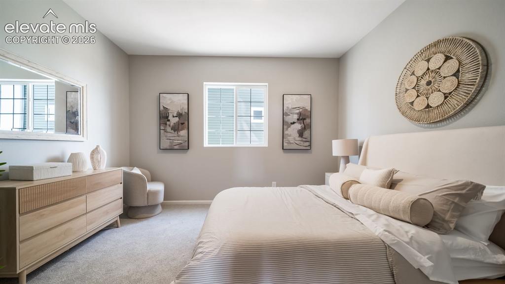 Image 10 of 39: Spacious bedroom featuring light gray wall paint, a double window with blin