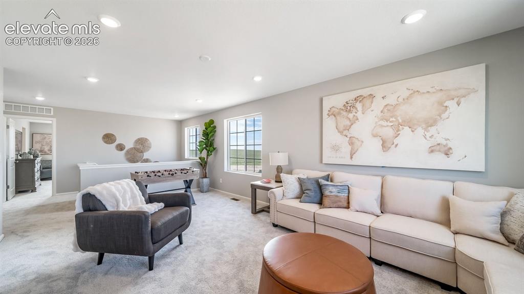 Image 19 of 39: Expansive carpeted room featuring recessed lighting, multiple windows, and