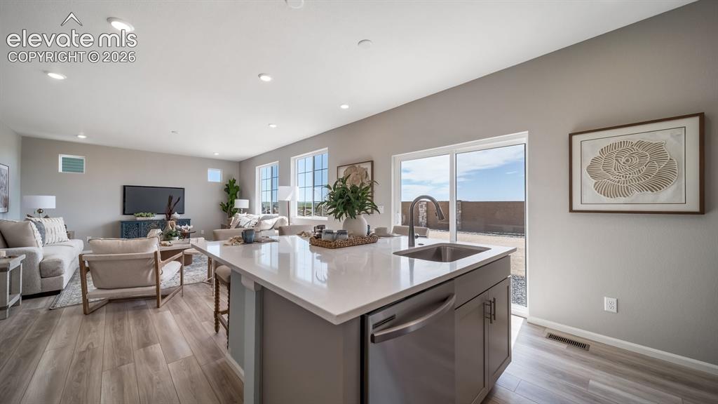 Image 23 of 39: Open-concept kitchen and living area featuring an island with an integrated
