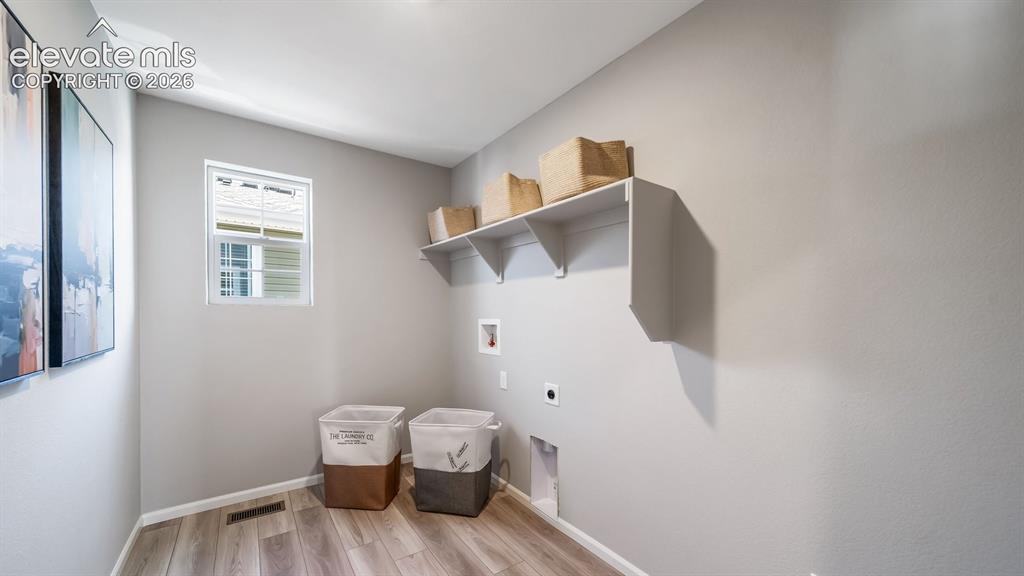 Image 25 of 39: Utility room featuring wood-finish flooring, a single window, built-in shel