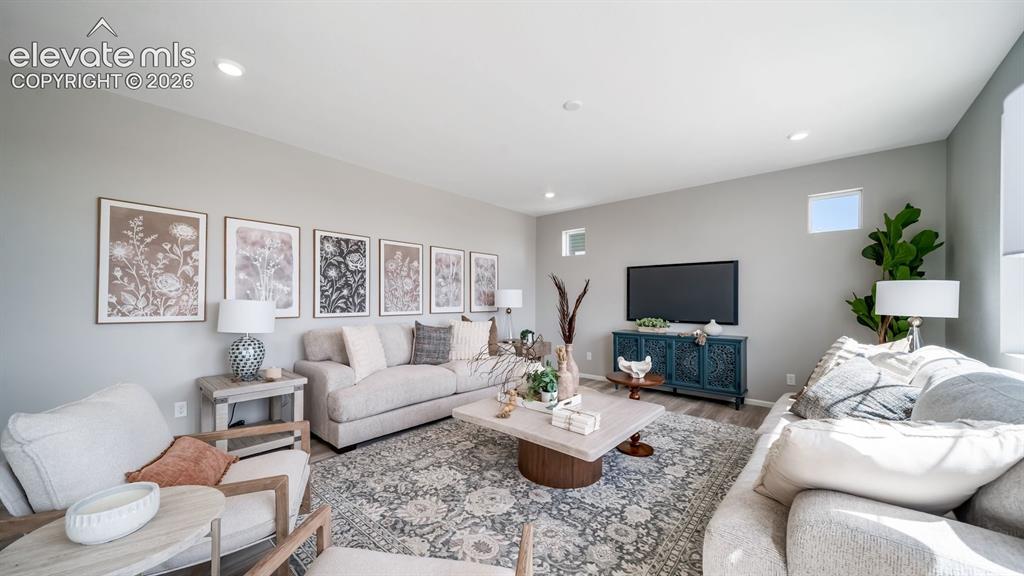 Image 26 of 39: Spacious living area featuring light-toned walls, recessed lighting, and wo