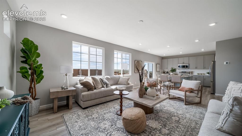 Image 28 of 39: Open-concept living space featuring wood-finish flooring and ample natural