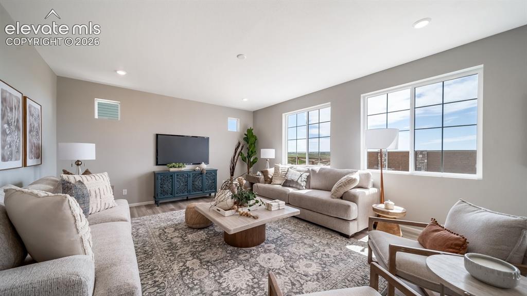 Image 29 of 39: Spacious living area featuring light-toned walls, recessed lighting, and wo