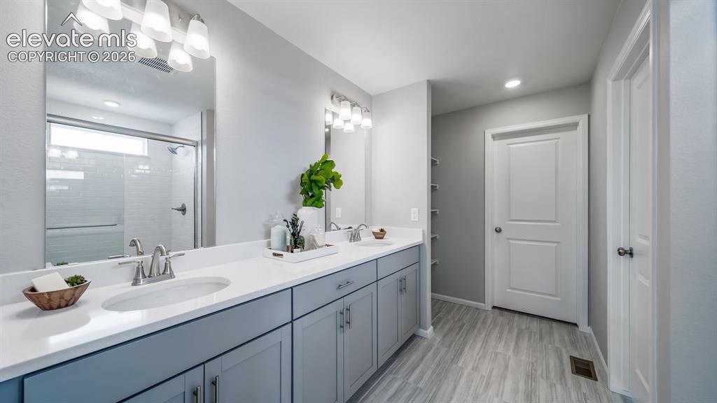 Image 32 of 39: Double vanity with integrated sinks, white countertops, and brushed nickel