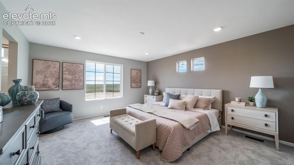 Image 34 of 39: Carpeted bedroom featuring a large window with grid panes, recessed lightin